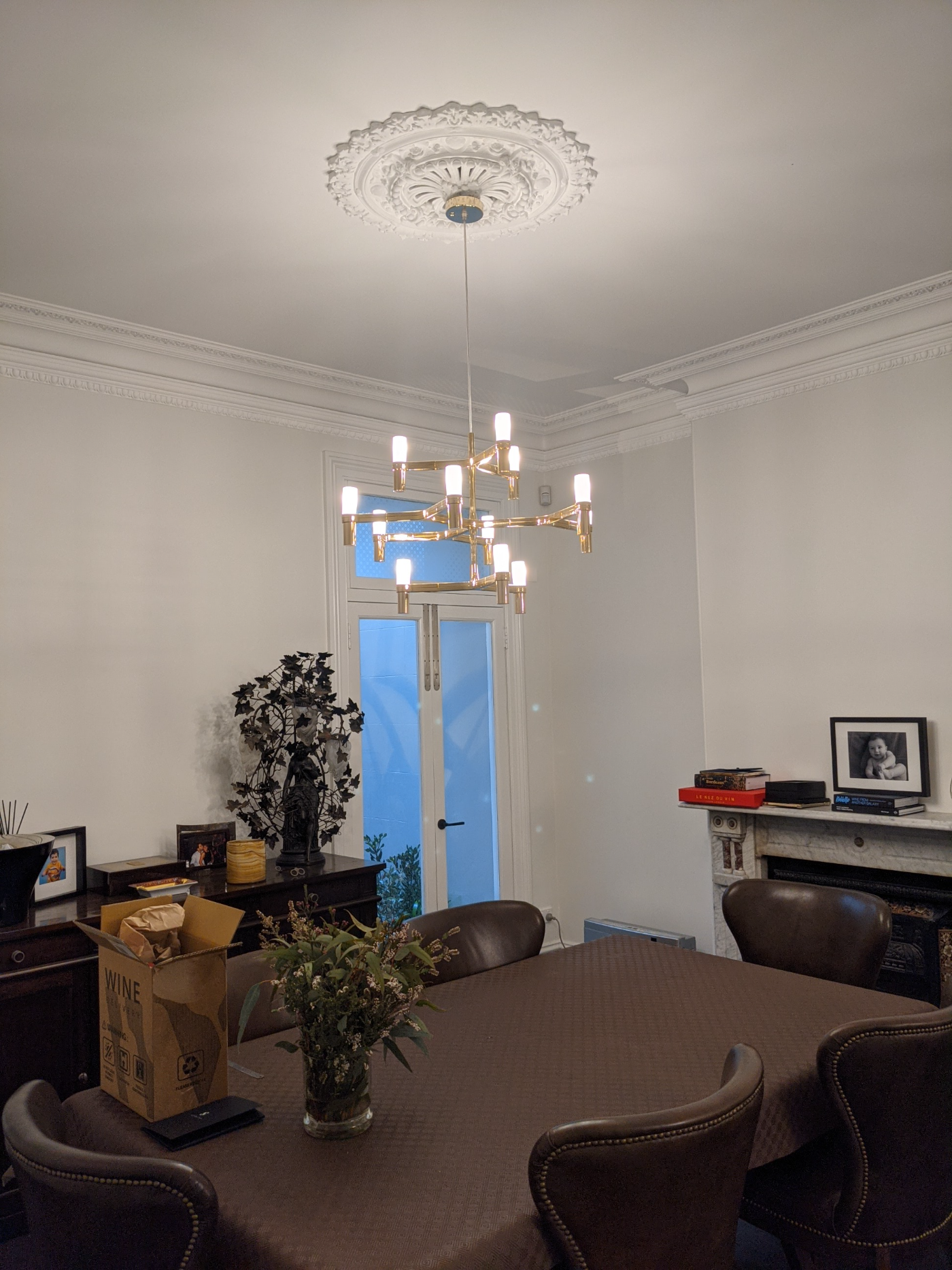 Brass chandelier installed under heritage ceiling rose, Sydney heritage home