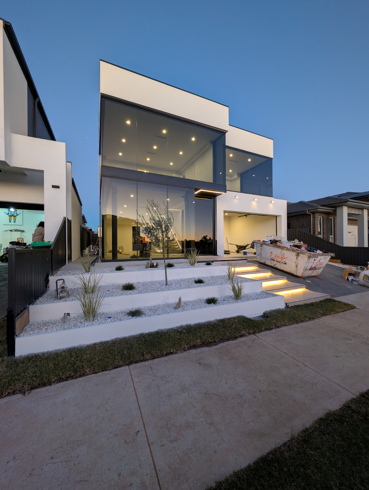 Modern double-storey home exterior with feature lighting at dusk, Sydney